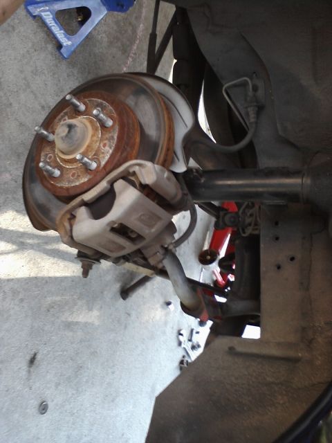 1995 Ford Taurus - Rear brake assembly of a car, showing the rotor, caliper, and suspension components.