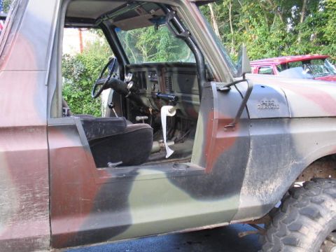 1979 Ford Bronco - This 1979 Ford Bronco features a camouflage paint job and a view of its interior, with a roll of toilet paper visible on the dashboard.