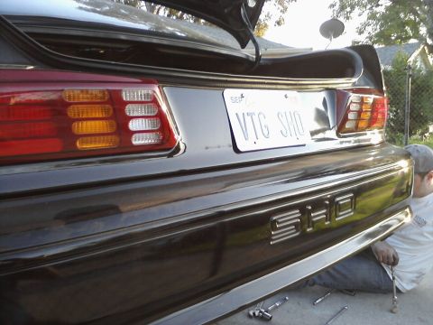 1995 Ford Taurus - Rear view of a black Ford Taurus SHO sedan with its trunk open, showing the license plate.