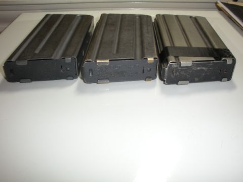 1996 Ford Bronco - Three metal rifle magazines are displayed on a white surface, with text visible on one of them.