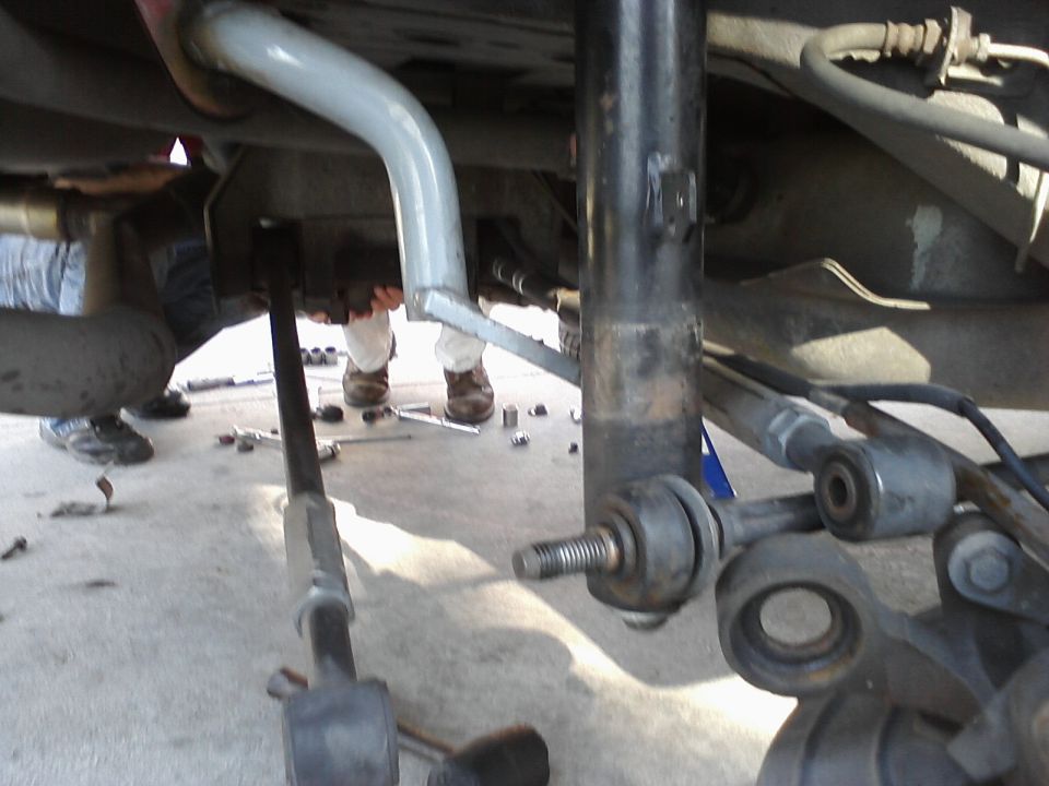 close-up of car's rear suspension components and exhaust pipe during repair