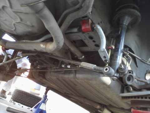1995 Ford Taurus - The undercarriage of a vehicle is shown, with suspension and exhaust systems clearly visible.