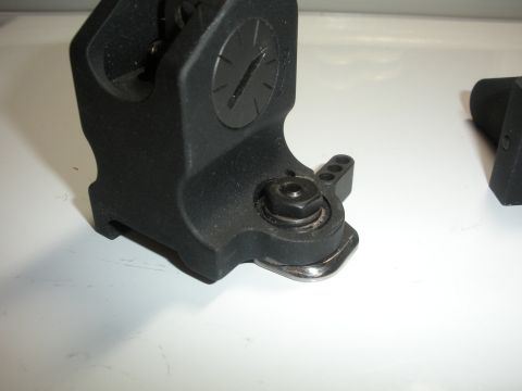 1996 Ford Bronco - Close-up of two black flip-up firearm sights, one in focus on a white surface.