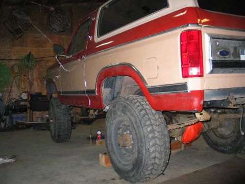 1984 Ford Bronco - This lifted Ford Bronco is shown in a garage with its rear end visible.