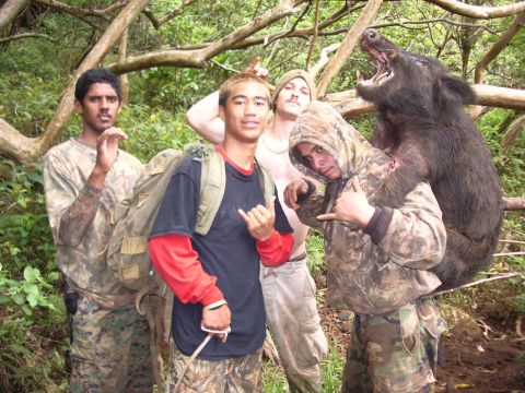 1991 Ford Bronco - Hunters pose with a wild boar they have caught in a wooded area.