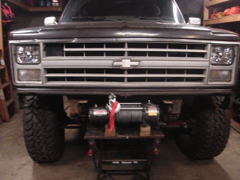 1989 Ford Bronco - A dark Chevrolet truck is shown from the front, a chrome grille and a winch mounted underneath.