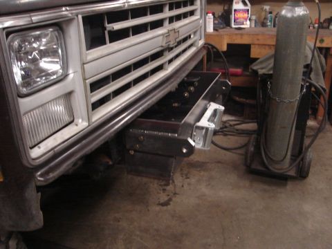 1989 Ford Bronco - A close-up view of a truck's front end, focusing on a newly installed custom bumper and a welding gas cylinder in the background.