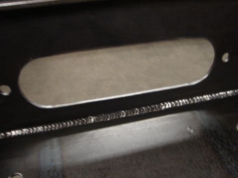 1989 Ford Bronco - This image shows a section of a metal frame with a distinctive oval cutout and detailed weld marks.