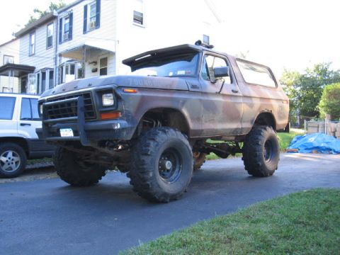 1979 Ford Bronco - This lifted 1979 Ford Bronco features a camouflage paint scheme and a prominent front brush guard.