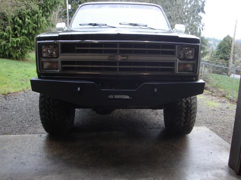 1989 Ford Bronco - Front view of a black Chevrolet K5 Blazer with an aftermarket bumper and off-road tires.