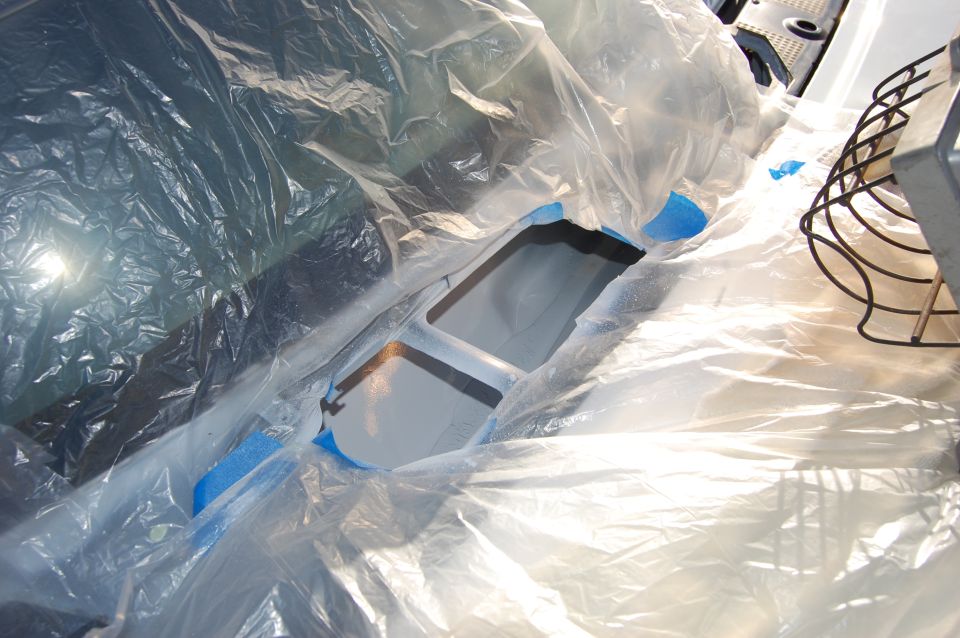 Vehicle interior covered in plastic sheeting, showing a central console area. Supermotors.net logo visible