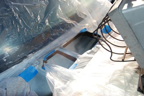 1994 Ford Bronco - The interior of a vehicle is covered in plastic and tape, preparing for a paint job.