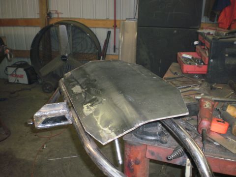 1995 Ford Bronco - A metal component is on a workbench, surrounded by tools and shop equipment.