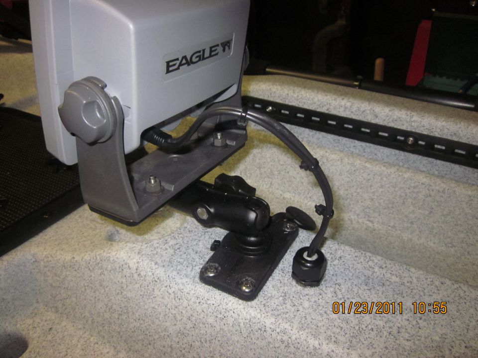 Eagle fish finder mounted on a black bracket with cables attached, set on a textured surface