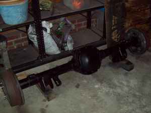 2000 Ford F-150 - A black rear axle assembly with drum brakes is shown with a SuperMotors logo in the corner.