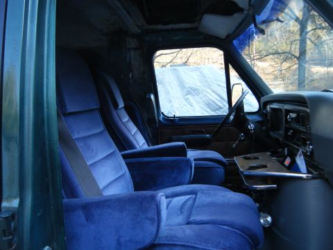 1981 Ford E350 - The interior of a 1981 Ford E350 van shows plush blue velour seating and a functional dashboard.