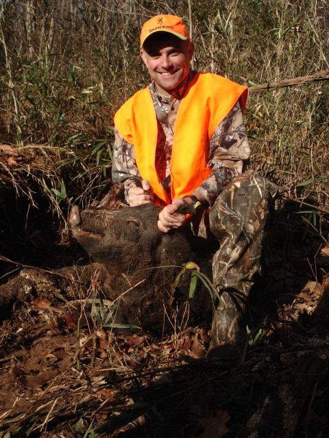 1992 Ford C-350 (Centurion Conversions) - Hunter proudly displays a wild boar after a successful hunt in a wooded area.