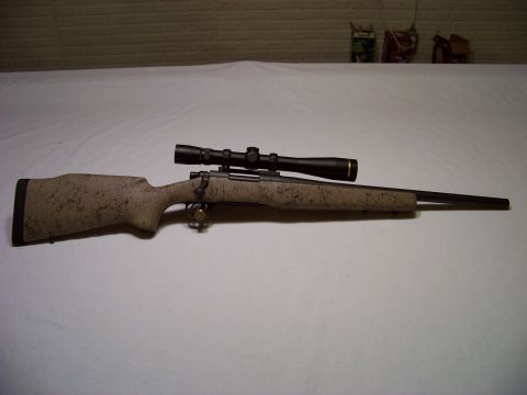 1995 Mercury Grand Marquis - A rifle with a scope is shown with a speckled camouflage stock and barrel.