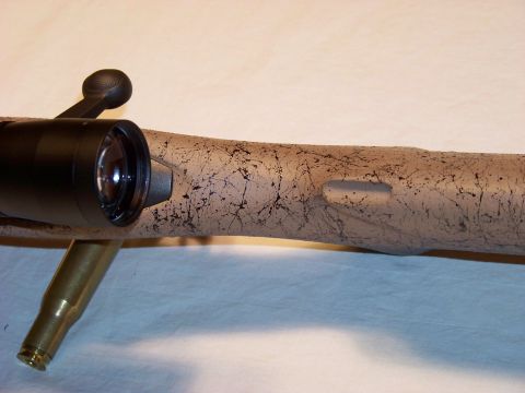 1995 Mercury Grand Marquis - Close-up of a rifle scope and stock, with a casing visible.