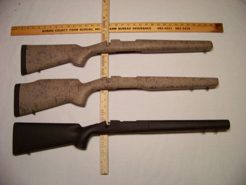 1995 Mercury Grand Marquis - Three gun stocks are displayed with rulers for scale. Two have a speckled camouflage pattern, and one is solid black.