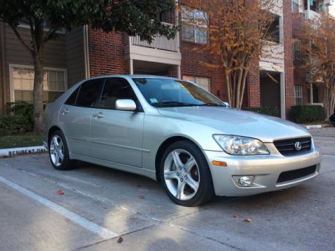 2008 Subaru Legacy - Silver Lexus IS sedan parked in a lot with a brick building and trees in the background.