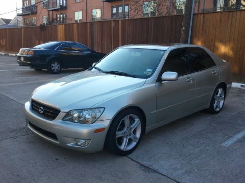2008 Subaru Legacy - A silver sedan is parked in a lot next to another car, with a wooden fence and building in the background.