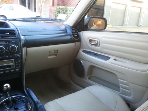 2008 Subaru Legacy - The interior of a beige car is shown, a tan dashboard, door panel, and seats, with a visible 'SUPERMOTORS' watermark.