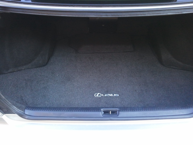 Trunk interior with a Lexus logo on the carpet mat. The trunk lid is open