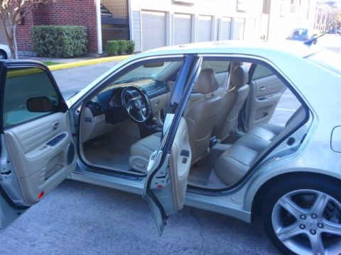 2008 Subaru Legacy - The interior of a Lexus IS sedan is visible with the front and rear doors open, revealing tan leather seats.
