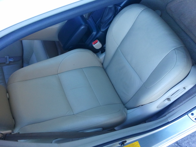 Front car seats, tan leather, with a dark center console and seatbelt