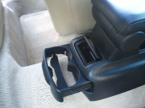 2008 Subaru Legacy - Close-up of a vehicle's interior center console, showing a cup holder and armrest.