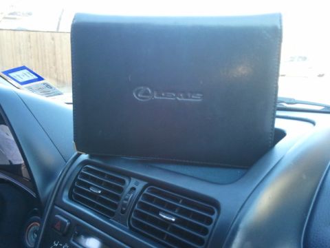 2008 Subaru Legacy - A black leather manual case with the Lexus logo is placed on the dashboard of a car.