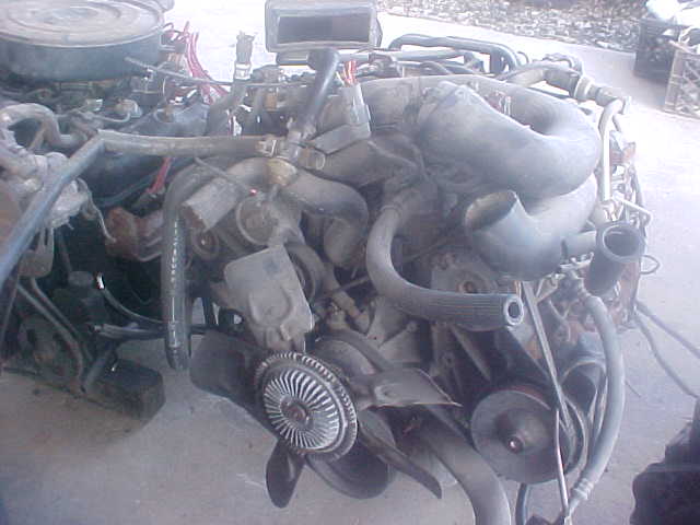 Engine assembly with hoses, belts, and fan visible