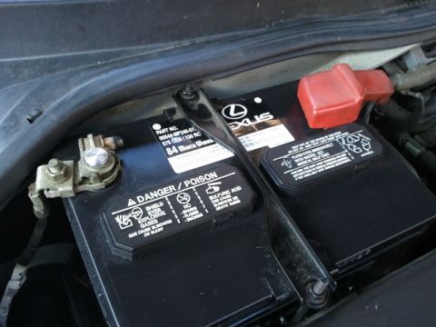 2008 Subaru Legacy - A car battery with a Lexus logo is visible under the hood.