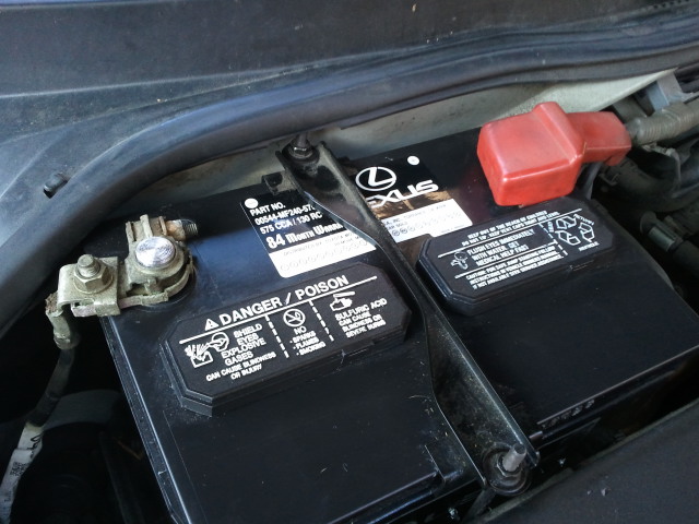 Car battery with Lexus logo, showing part number and danger warnings