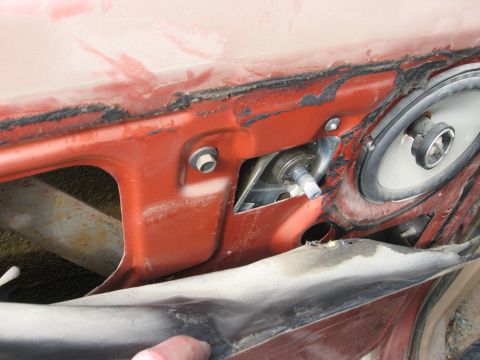 1981 Ford Bronco - Interior view of a vehicle's red door panel, revealing the speaker and window operating mechanism.