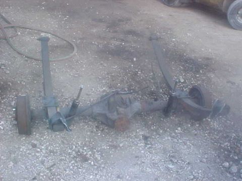 1996 Ford Bronco - A rear axle assembly, likely from a truck or SUV, is shown disassembled on a gravel surface.