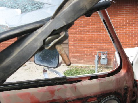 1981 Ford Bronco - Close-up view of the windshield frame and mirror mounting area of a vehicle.