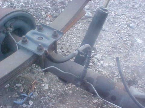 1996 Ford Bronco - Close-up view of a vehicle's rear axle assembly, including leaf springs and a shock absorber. The Supermotors.net logo is present in the lo…
