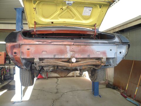 1975 Ford Ranchero - Vehicle undergoing repair, rear section exposed on a car lift.