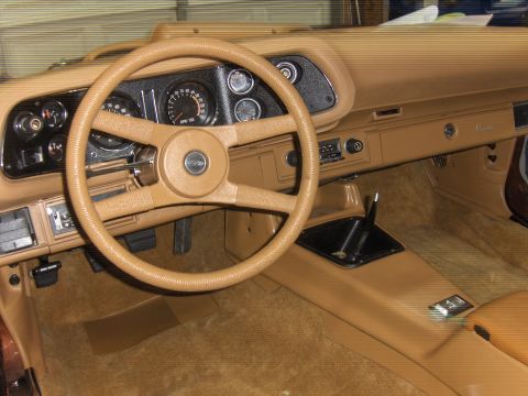1982 Chevrolet Camaro - The interior of a 1982 Chevrolet Camaro shows a tan dashboard, steering wheel, and center console.