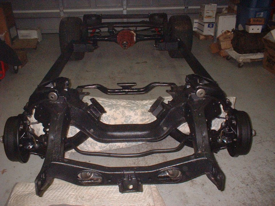 Car frame with front and rear suspension assemblies, wheels attached