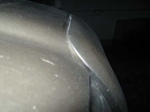 2000 Mercury Grand Marquis - A close-up view of the exterior body paneling of a vehicle, focusing on the seam between the fender and bumper.