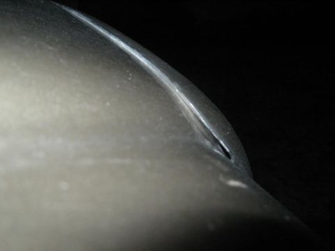 2000 Mercury Grand Marquis - A close-up view of a car's body panel reveals a distinct crease and a small gap, with a watermark at the bottom right.