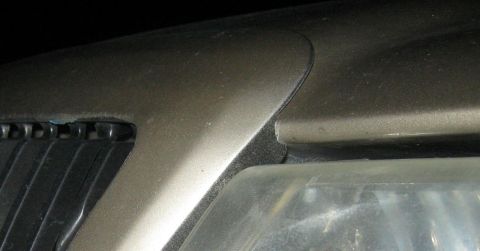 2000 Mercury Grand Marquis - Close-up view of the grille and headlight assembly on a gold 2000 Mercury Grand Marquis.