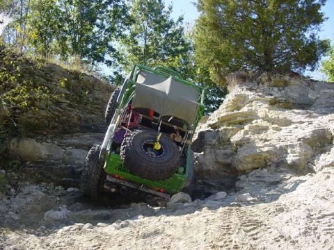 1992 Ford Bronco - This vehicle is navigating a challenging rocky terrain, with its rear end angled upwards.