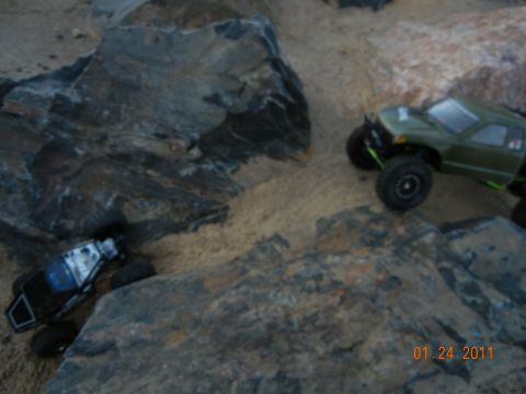 1996 Ford Bronco - RC rock crawlers traverse a challenging obstacle course made of rocks and sand.