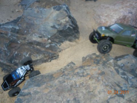 1996 Ford Bronco - Two remote control rock crawlers navigate a challenging rocky and sandy obstacle course.