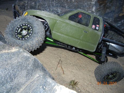 1996 Ford Bronco - A green remote control rock crawler navigates a rocky terrain.