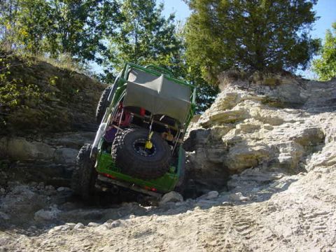 1992 Ford Bronco - A modified off-road vehicle tackles a challenging rocky terrain.